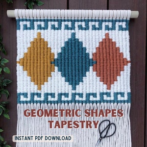 Op de afbeelding: Een witte macramé wandhanger met een geometrisch ontwerp met een turquoise cirkel, een mosterdgele ruit en een verbrand oranje ruit. De wandhanger heeft witte franjes en de tekst "Geometric Shapes Tapestry" en "Instant PDF Download" is onder het ontwerp gedrukt.