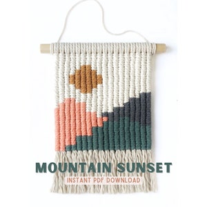 May include: A macrame wall hanging with a geometric mountain sunset design in shades of white, peach, green, gray, and brown. The text "MOUNTAIN SUNSET" and "INSTANT PDF DOWNLOAD" is printed below the hanging.