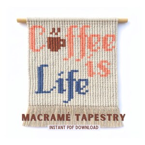 May include: A beige macrame tapestry with the words "Coffee is Life" in orange, brown, and blue yarn. The tapestry has fringe on the bottom and is hanging from a wooden dowel.