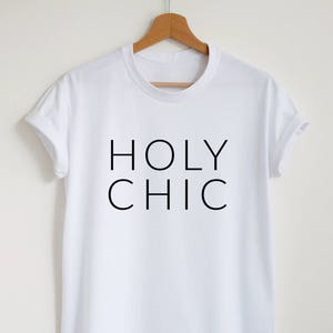 May include: White t-shirt with black text that reads "HOLY CHIC"