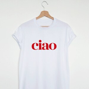 May include: White t-shirt with the word "ciao" printed in red.