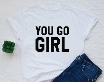 May include: White t-shirt with black text that reads "You go girl".