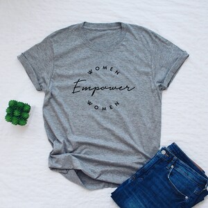 May include: Gray t-shirt with the text "Women Empower Women" in a circle.