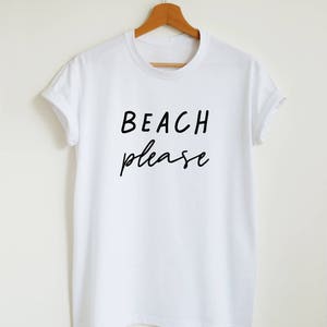 May include: White t-shirt with black text that reads "BEACH please" in a handwritten font.