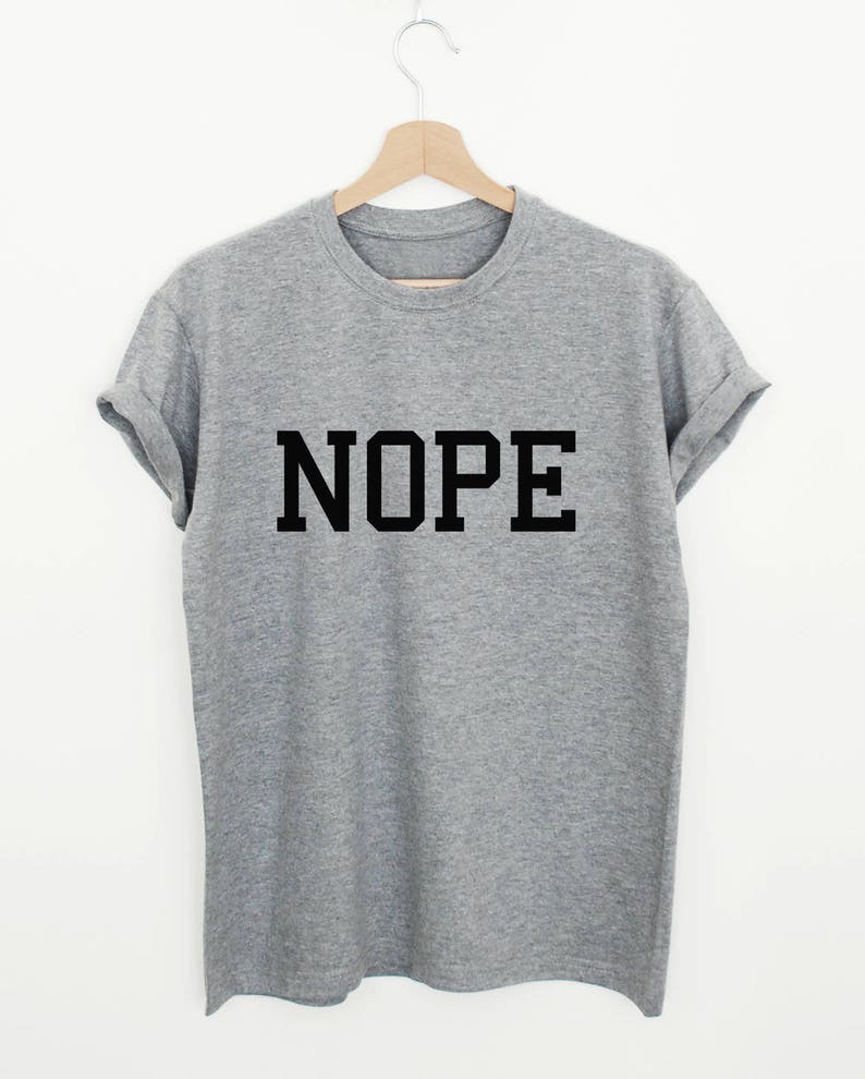 May include: A gray t-shirt with the word "NOPE" printed in black block letters.