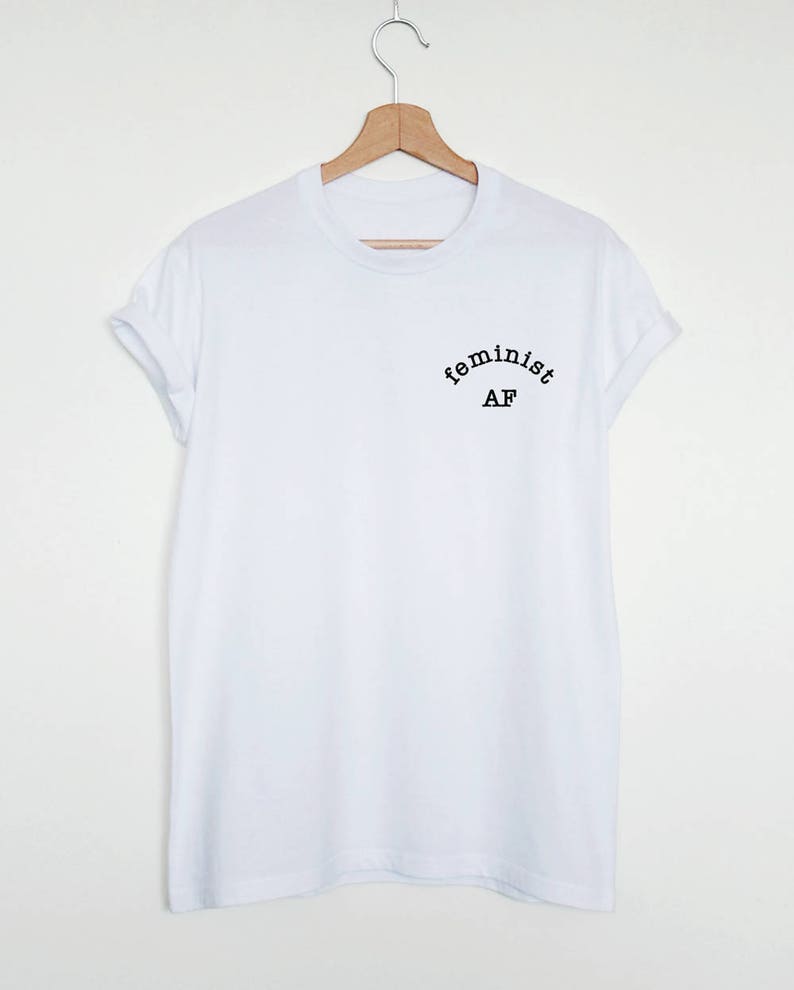 May include: White t-shirt with black text that reads "feminist AF" in an arc.
