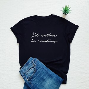 May include: A black t-shirt with white text that reads "I'd rather be reading."