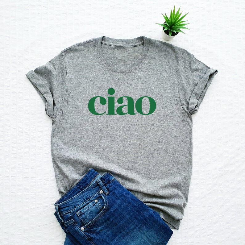 Pode incluir: Uma camiseta cinza com um gr&aacute;fico verde "ciao" estampado na frente.
