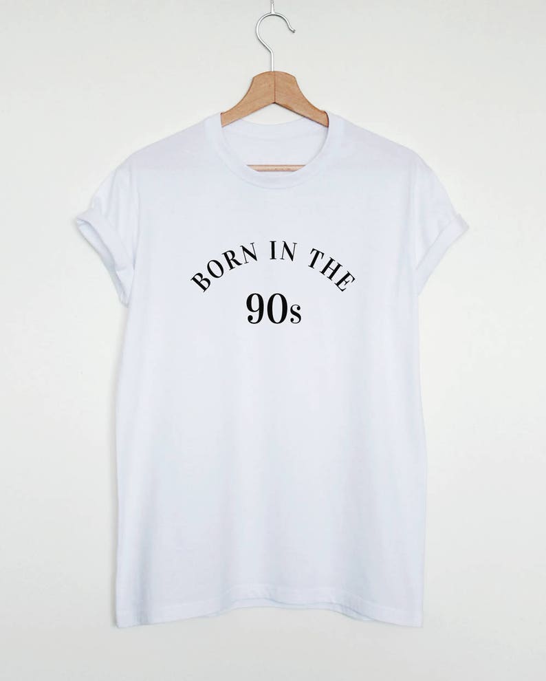May include: White t-shirt with black text that reads "Born in the 90s".