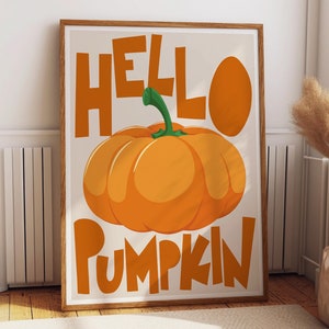 Könnte beinhalten: Ein gerahmter Druck mit dem Text "Hello Pumpkin" in orangefarbenen Buchstaben. Ein großer orangefarbener Kürbis mit einem grünen Stiel befindet sich in der Mitte des Drucks.