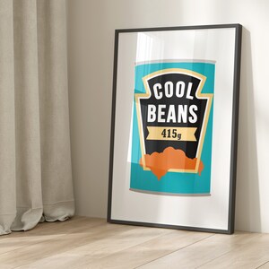 Op de afbeelding: Een ingelijst afdruk van een blauw en wit blik bonen met de tekst "COOL BEANS 415g" op het etiket.