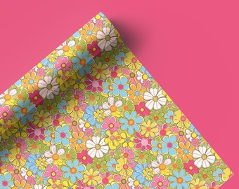 May include: A sheet of colorful wrapping paper with a pattern of bright pink, yellow, blue, and green flowers. The paper is rolled up and the corner is folded over.