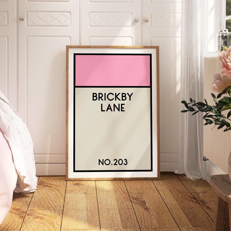 May include: A framed print with a pink and beige color scheme. The print features the text "Brickby Lane" and "No. 203".