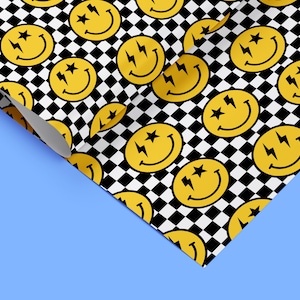 May include: A yellow smiley face with lightning bolts and stars for eyes is repeated on a black and white chequered background. The pattern is wrapped around a corner of a blue surface.