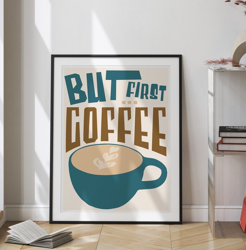May include: A framed poster with a teal and brown illustration of a coffee cup with the text "BUT FIRST COFFEE" in a retro style.