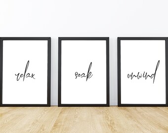 May include: Three black framed prints with white backgrounds and black calligraphy. The prints read "relax", "soak", and "unwind".