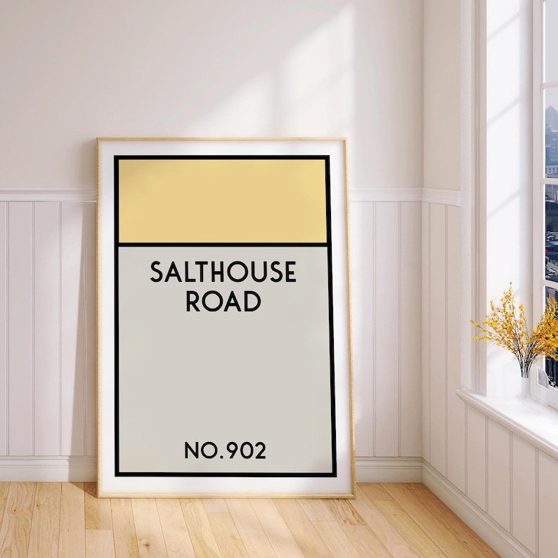 May include: A framed print with a yellow and gray color scheme. The print features the text "Salthouse Road" and "No. 902".