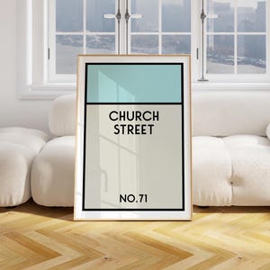 May include: A framed print with a light blue and beige background. The print features the text "CHURCH STREET NO.71" in black.