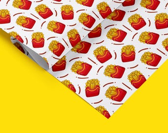 May include: A white background with a repeating pattern of red and yellow cartoon french fries in a red box. The pattern is repeated on a white sheet of paper that is folded over a yellow surface.