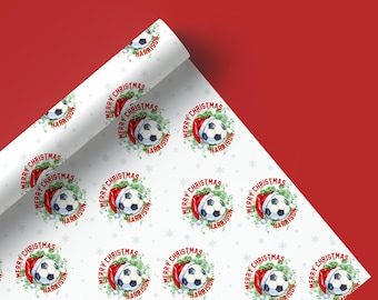 May include: White wrapping paper with a repeating pattern of green wreaths, red Santa hats, and soccer balls. The text "Merry Christmas Harrison" is printed on each wreath.