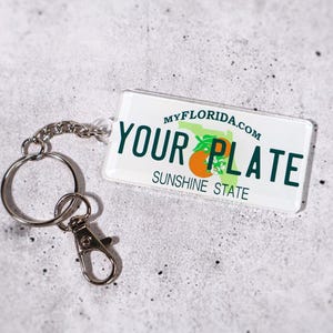 Unique gift idea for car lovers — custom license plate keychain available in all 50 U.S. states. Personalize with your name or message for a one-of-a-kind accessory. Perfect for birthdays, graduations, or new drivers. Acrylic design with metal chain ensures durability and shine. A fun and collectible replica plate keychain to celebrate your favorite destination.