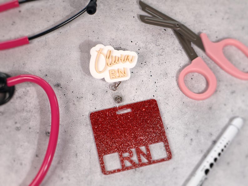 Custom acrylic badge reel engraved with name Olivia and title RN. Personalized retractable ID holder for nurses, CNAs, and healthcare professionals. Shown in white base with gold text, featuring 360° alligator clip and 25-inch retractable cord. Durable, lightweight, and handcrafted acrylic design perfect for hospital staff, clinics, and nurse week gifts. Stylish and functional nurse badge reel made in the USA.