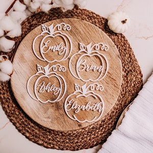 Custom wood name tags for Friendsgiving, Thanksgiving, or fall weddings. These engraved pumpkin-shaped place cards help organize your table setting while doubling as cute seasonal gifts for guests to take home.