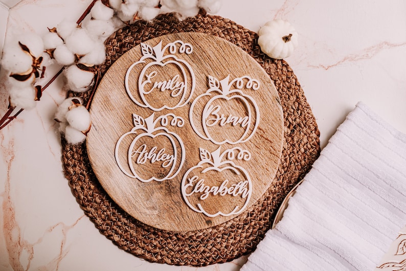 Custom wood name tags for Friendsgiving, Thanksgiving, or fall weddings. These engraved pumpkin-shaped place cards help organize your table setting while doubling as cute seasonal gifts for guests to take home.