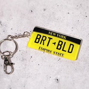 Personalized license plate keychain for new drivers — customizable with your text, initials, or numbers. Acrylic tag replicates real U.S. license plates for a fun, authentic look. Ideal car accessory and thoughtful gift for teens, graduates, or first-time car owners. A small but memorable keepsake for anyone celebrating a new car or license milestone.
