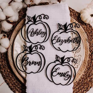 Custom name tags shaped like pumpkins for Thanksgiving table decorations. These wood or acrylic place cards are engraved with guest names and come in five finish options, making them a perfect fit for holiday dinners or festive events.