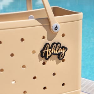 Cute personalized Bogg Bag charm – name plate and keychain for school or travel bags black and gold Bogg Bag Gift Ideas,
Pink Bogg Bag,
Bogg Bag Charms,
Name Plate Bogg Bag,
Bogg Bag Accesories,
Initial Bogg Bag,
Customize Bogg Bag,
Cute Bogg Bag,
Bogg Bag chain,
Name Tag Bogg Bag,
Personalized Charm,
Crocs Bag Name