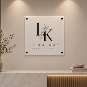 Weather-resistant square acrylic storefront plaque with UV printed company branding and black mounting hardware on an exterior wall.
