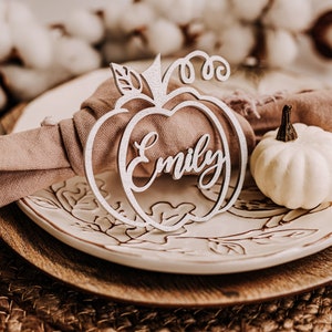 Handcrafted fall pumpkin name signs used as custom place cards for Thanksgiving dinner or Friendsgiving parties. Available in raw wood, gold, silver, black, white, orange, peach, glitter gold, black, copper or mirrored gold acrylic, adding warmth and personalization to your seasonal table decor.