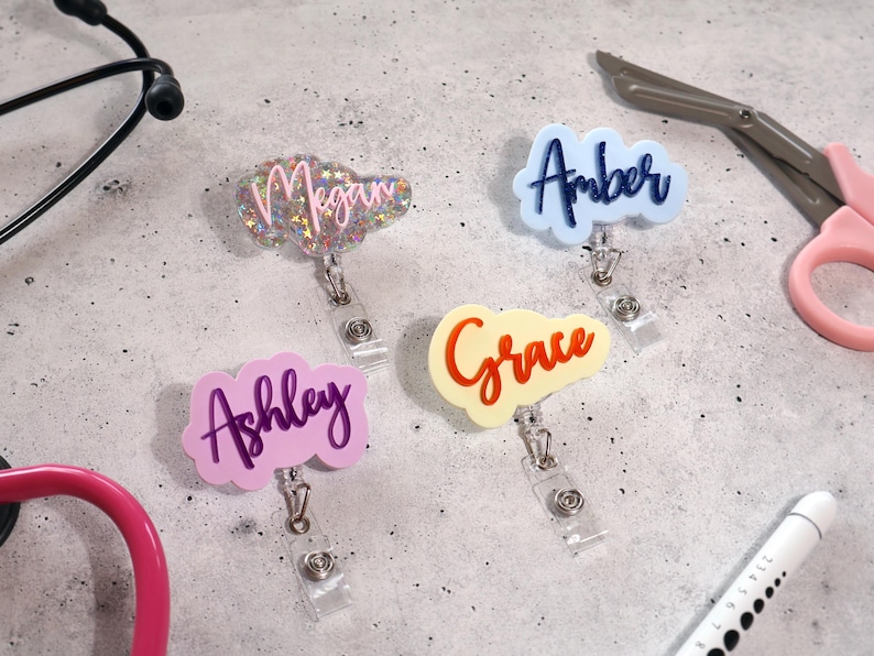 Group of personalized acrylic badge reels in mixed pastel and glitter colors. Custom name tag reels for nurses, teachers, and medical professionals. Retractable ID holders with alligator clips, handcrafted in the USA. Perfect for hospital ID, clinic staff, or office employees. Unique gift idea for nurse week, coworker, or teacher appreciation.