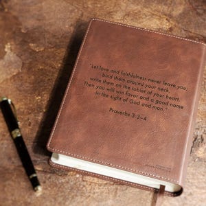 Close up detail of engraved personalized NIV Bible cover for wedding gift. Custom leather family Bible guest book for bride and groom, Christian wedding keepsake, anniversary milestone gift.