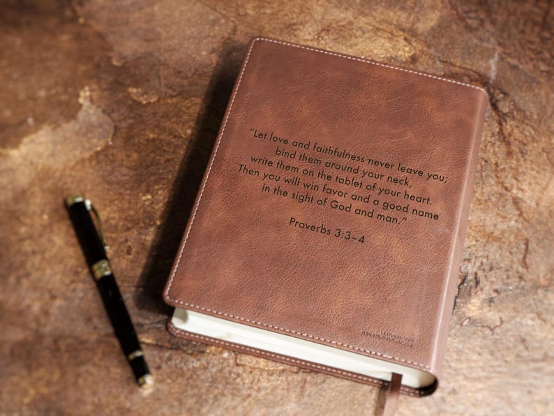 Close up detail of engraved personalized NIV Bible cover for wedding gift. Custom leather family Bible guest book for bride and groom, Christian wedding keepsake, anniversary milestone gift.