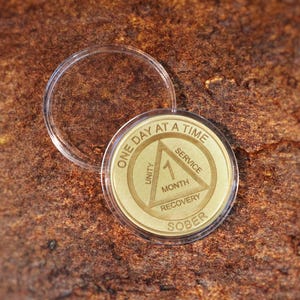 Laser engraved Alcoholics Anonymous sobriety coin with One Day at a Time message custom recovery chip for 1 month to multi year sober anniversary.