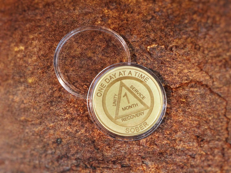 Laser engraved Alcoholics Anonymous sobriety coin with One Day at a Time message custom recovery chip for 1 month to multi year sober anniversary.