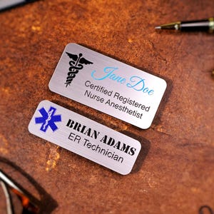Personalized magnetic name tags with UV-printed company logos in color on gold and silver backings. Custom employee name badges for office, salon, or medical staff uniforms. Durable acrylic name tags with professional full-color printing.
