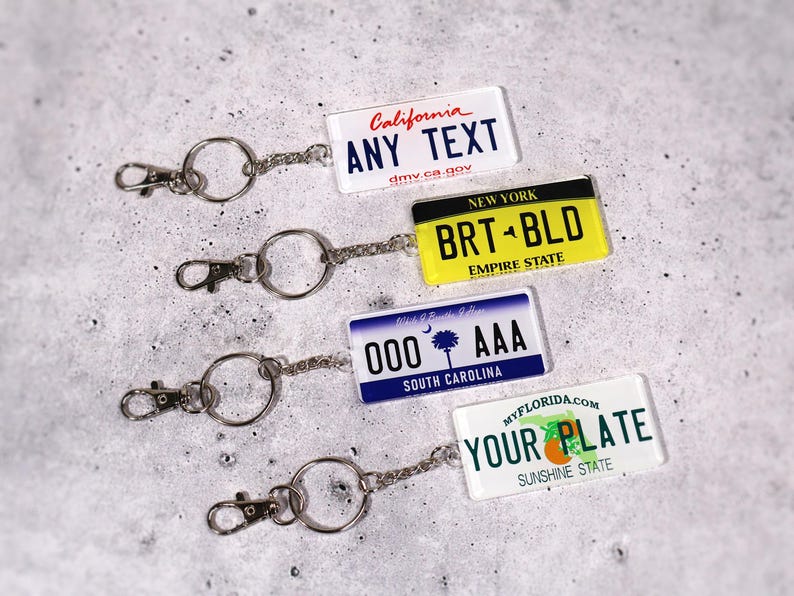 Car lover’s license plate keychain printed with your personalized message. Choose any state design for a fun and unique gift. Made from high-quality acrylic and attached to a sturdy metal keyring. Perfect for car enthusiasts, road-trip fans, and new drivers. A creative small gift that combines style and practicality for everyday keychain use.