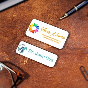 Custom logo magnetic name badge printed in full color with company emblem and employee title. Professional office name tags for businesses, real estate agents, and healthcare staff. High-quality UV-printed acrylic badge with metallic finish.