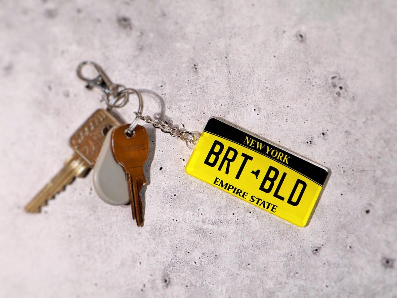 Personalized license tag keychain printed on premium acrylic with realistic state plate design. A great gift for car lovers, new drivers, and collectors. Choose any text, number, or location to create your own mini license plate keychain. A fun car key accessory that makes everyday driving more personal — perfect for birthdays, graduations, or stocking stuffers.