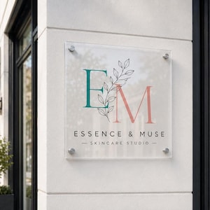 Colorful custom business logo printed on a clear square acrylic wall display with silver hardware in a bright modern office.