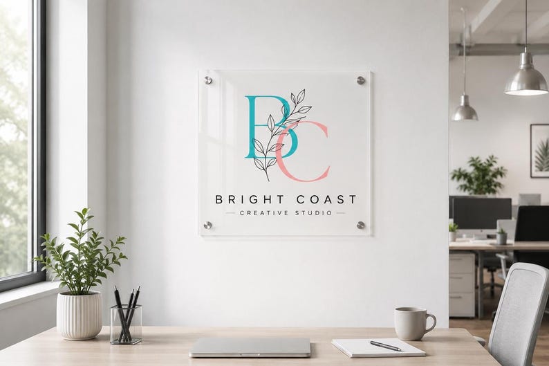 Custom painted acrylic business plaque with a colorful logo and black mounts displayed on a dark brick building facade.