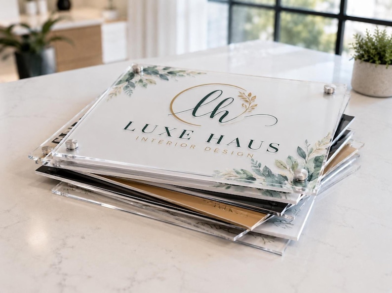 Stack of custom square acrylic logo plaques showing clear, white, black, and gold background options for business branding.