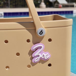 Pastel lavender and white Unique Bogg Bag gift idea – custom acrylic name charm for Crocs-style tote bags
Stylish Bogg Bag name plate – personalized charm for organizing and accessorizing your bag Bogg Bag Bits, 
Bogg Bag Buttons,
tag for bogg bag,
bogg bag name tag,
custom name tag,
luggage tag,
bogg bag accessories,
custom name bogg bag,
bogg bag Jibbitz
Personalized Bag, Bogg Bag Gift Ideas,
Pink Bogg Bag,
Bogg Bag Charms,
Name Plate Bogg Bag,
Bogg Bag Accesories,
Initial Bogg Bag