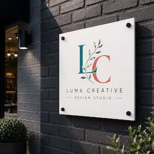 Square UV printed acrylic logo plaque with gold lettering and gold mounts displayed above a contemporary front desk.