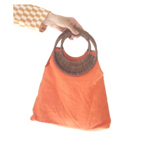 Bolso vintage Guerlain naranja brillante, estilo bohemio art déco con asa de madera.
