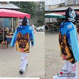 Pu&ograve; includere: Una felpa con cappuccio caratterizzata da uno sfondo blu a tema spaziale con un grande ritratto di un pastore tedesco sul retro. Il cappuccio mostra una grafica di Topolino con la scritta MICKEY YOU. Le maniche sono azzurre, abbinate a pantaloni bianchi.
