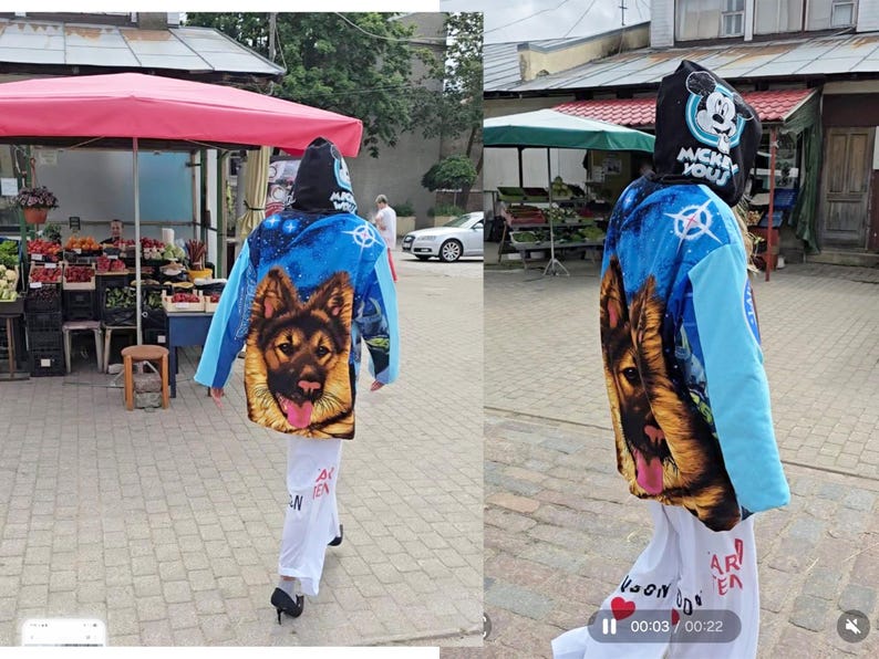 Pu&ograve; includere: Una felpa con cappuccio caratterizzata da uno sfondo blu a tema spaziale con un grande ritratto di un pastore tedesco sul retro. Il cappuccio mostra una grafica di Topolino con la scritta MICKEY YOU. Le maniche sono azzurre, abbinate a pantaloni bianchi.